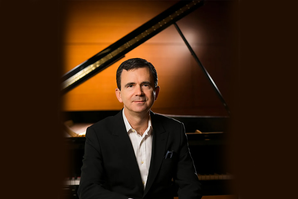 James Giles sits in front of a piano