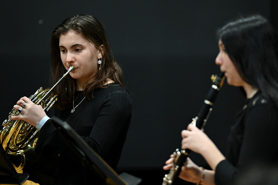 A woman playing the horn and a woman playing the clarinet in the Performance Studio