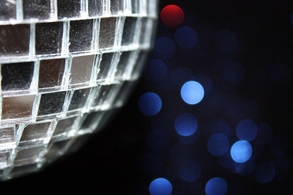 A graphic of a silver disco ball on a navy background