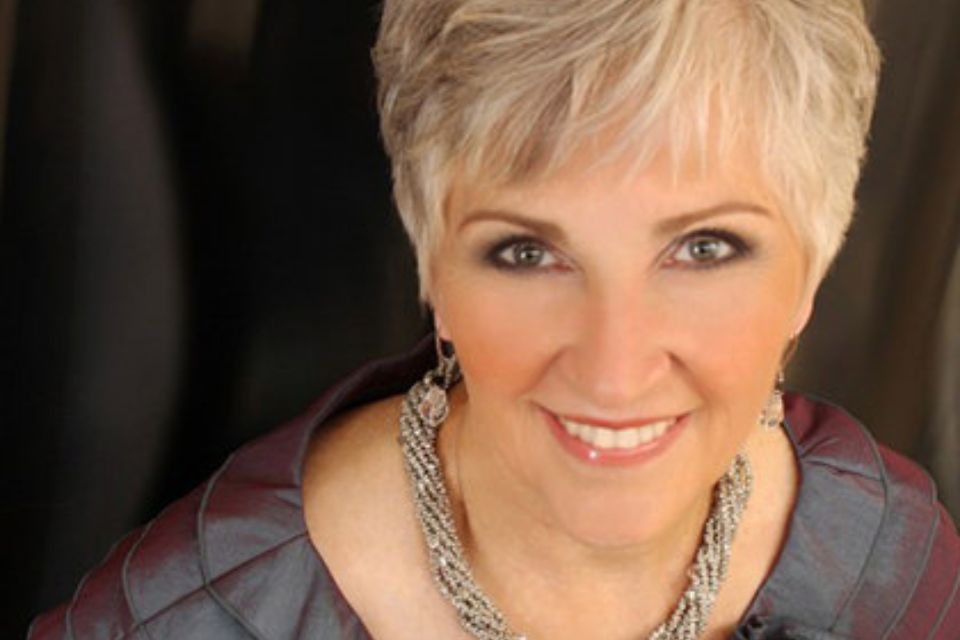 Gail Williams wears a thick necklace and looks up smiling