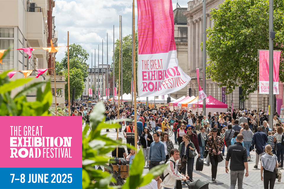 Lots of people walk around a sunnry street, with banners saying Great Exhibition Road Festival above them