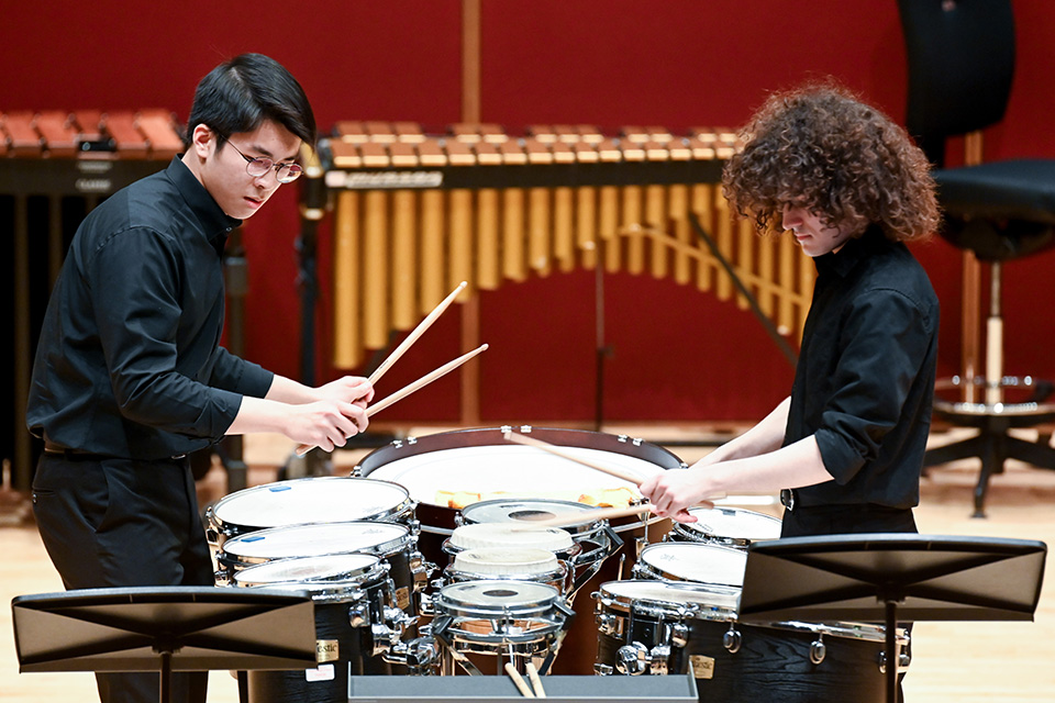 Two percussionists perform on stage