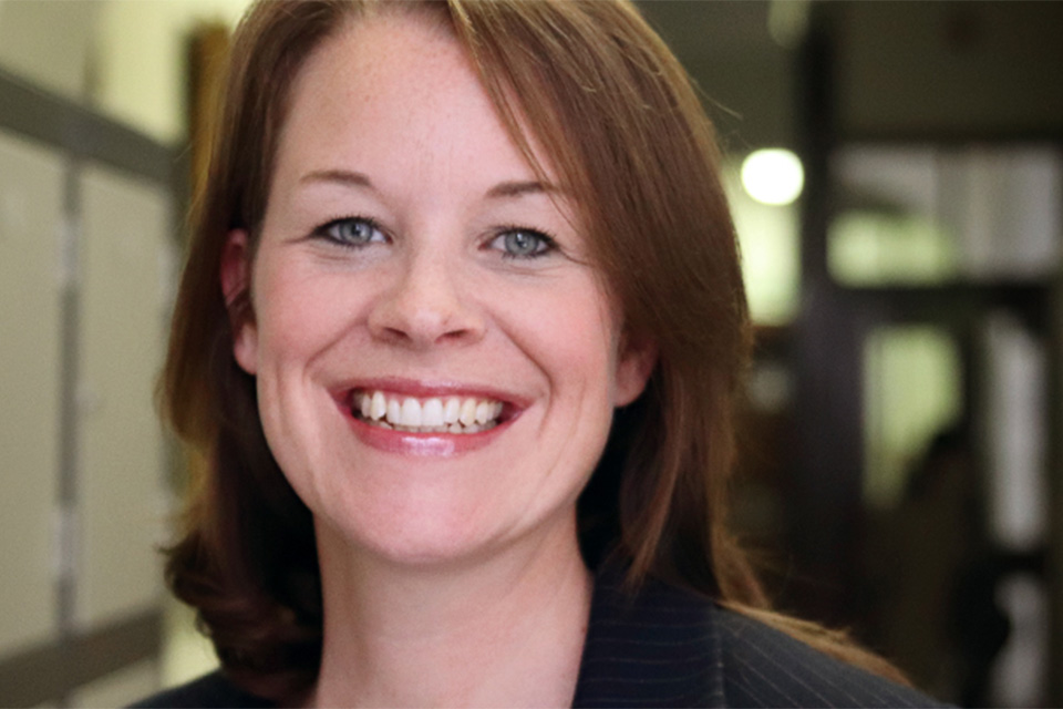 Hayley Clements, a woman with brown hair, smiles broadly at the camera