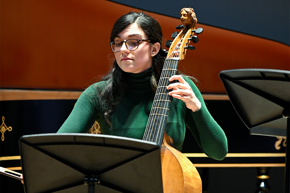 A young woman plays a viol