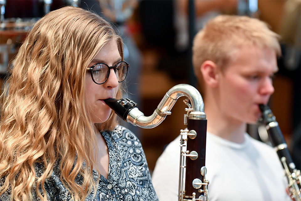 A young girl plays the bass clarinet