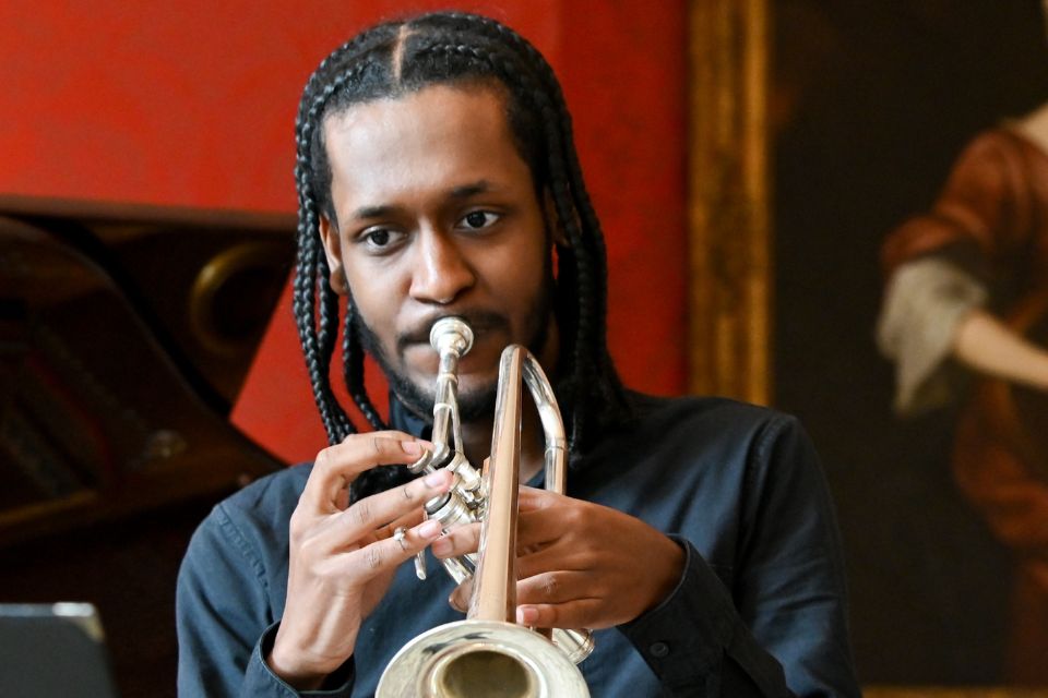 A young boy in a black shirt plays the trumpet