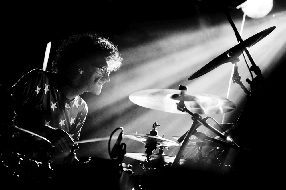 A black and white image of drummer Jojo Mayer performing on a drumkit