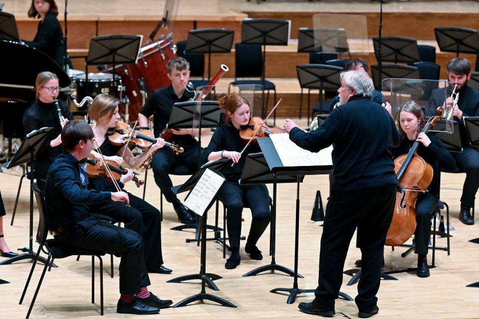 A large ensemble of musicians perform on stage