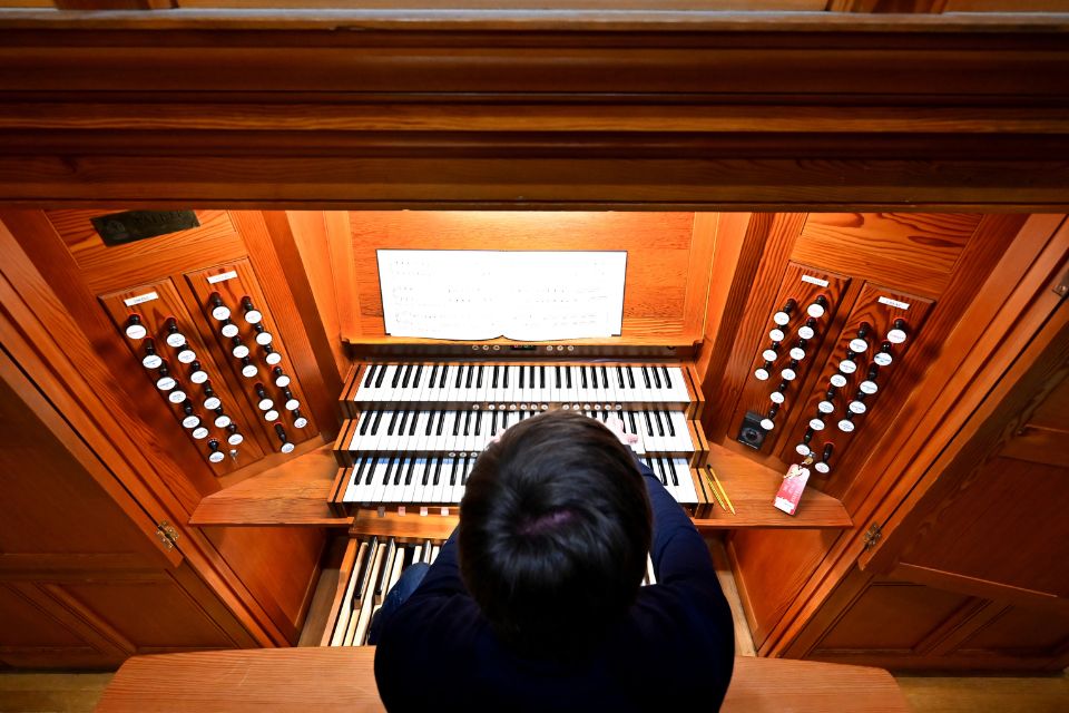 An aerial shot of a young man wearing black playing the organ
