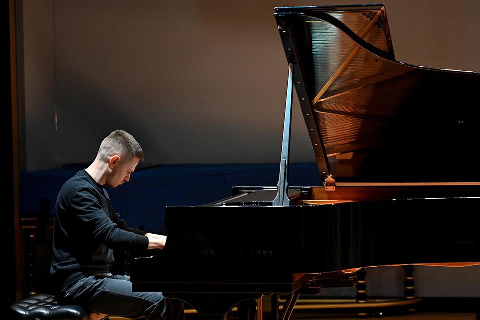 A man plays the piano on stage