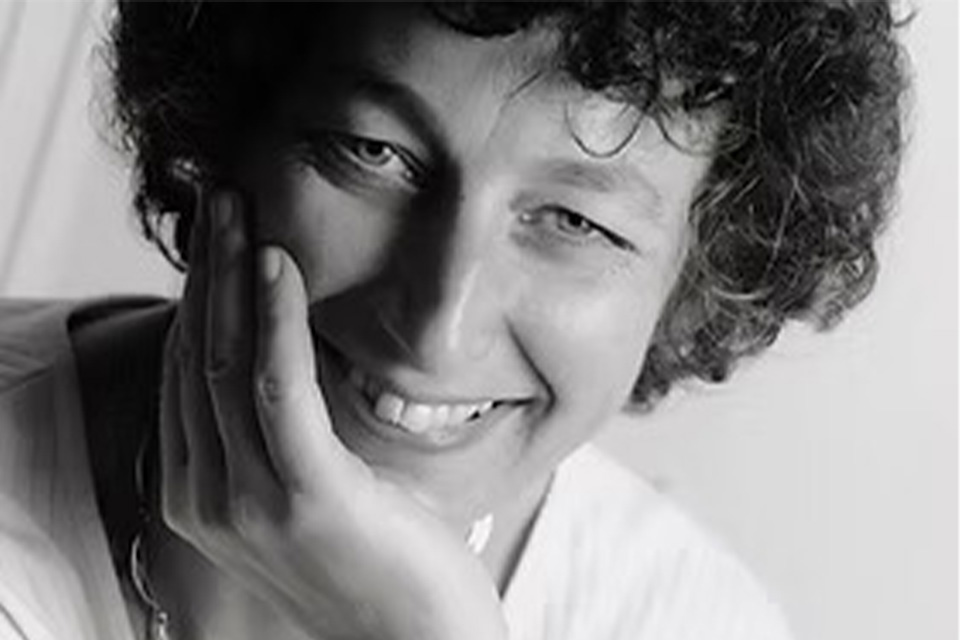 A black and white photo of Viola de Hoog smiling to camera