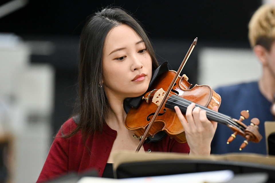 A young woman plays the violin